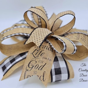 May include: A burlap and black and white checked ribbon bow with a burlap ribbon that says "Eternal Life for God so loved" and a scripture reference "John 3:16".