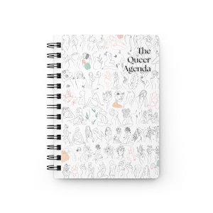 May include: A white spiral bound notebook with a black and white line drawing pattern of figures and flowers. The text "The Queer Agenda" is printed in black at the top of the notebook.