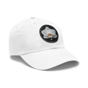 May include: White baseball cap with a black and white embroidered patch of a white orchid flower.
