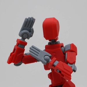 May include: A red and gray articulated action figure with posable arms and legs. The figure is in a fighting pose with one arm raised and the other arm bent at the elbow.
