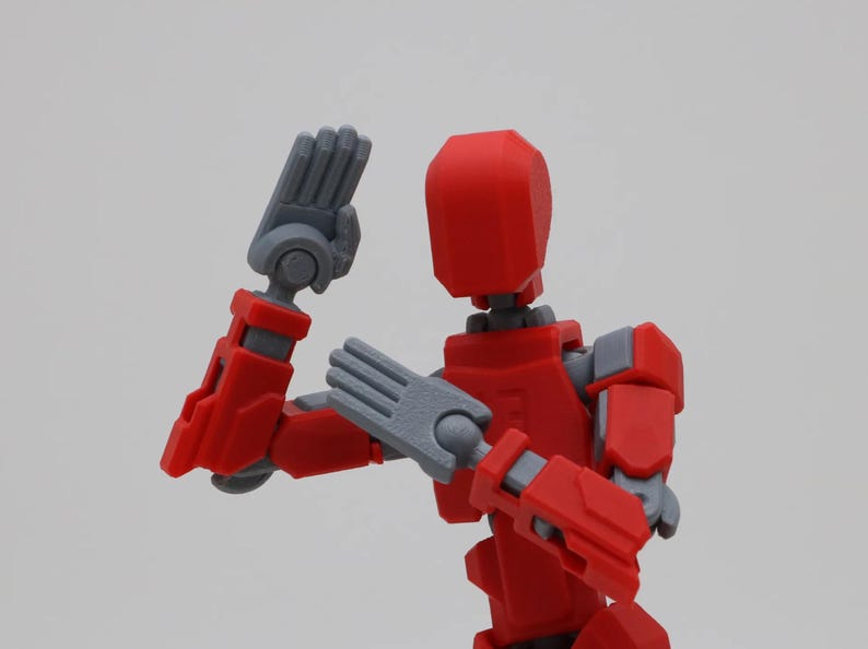 May include: A red and gray articulated action figure with posable arms and legs. The figure is in a fighting pose with one arm raised and the other arm bent at the elbow.