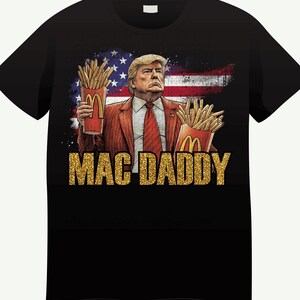 May include: Black t-shirt featuring a graphic of a man holding McDonald's french fries, with an American flag background. The text "MAC DADDY" is in gold glitter. The man is wearing a red tie and suit.