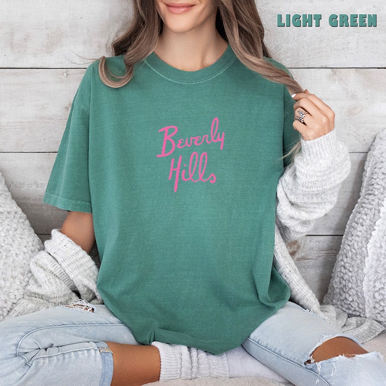 May include: A light green t-shirt with the text "Beverly Hills" in pink lettering.