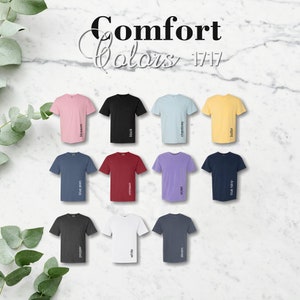 May include: A chart of 12 t-shirt colors with the names of each color printed below the shirts. The colors are: blossom, black, chambray, butter, blue jean, crimson, violet, true navy, pepper, white, denim.