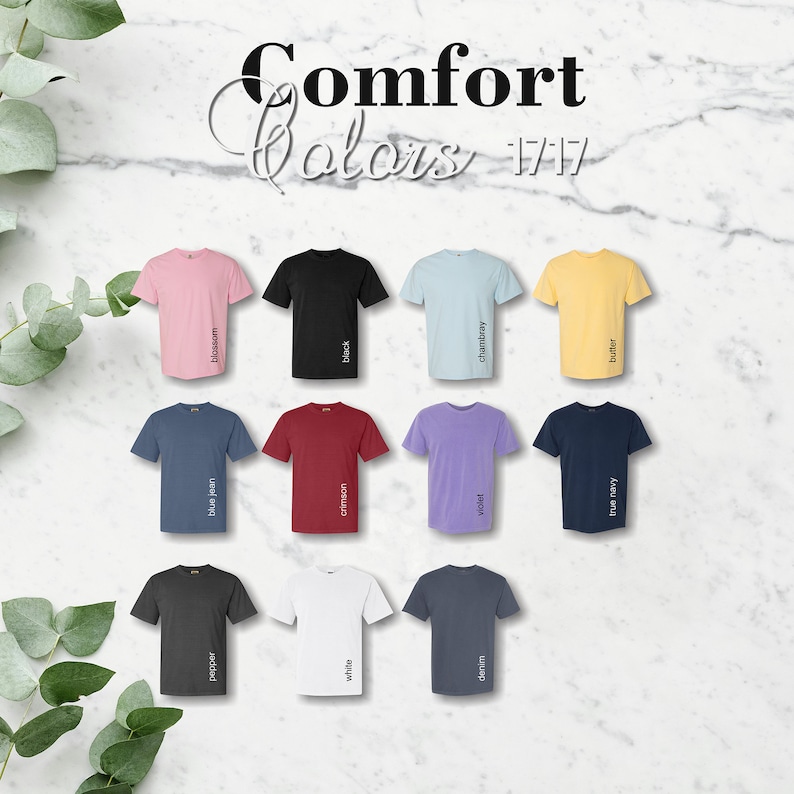 May include: A chart of 12 t-shirt colors with the names of each color printed below the shirts. The colors are: blossom, black, chambray, butter, blue jean, crimson, violet, true navy, pepper, white, denim.