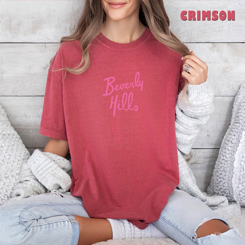 May include: A crimson red t-shirt with a pink graphic that says "Beverly Hills".