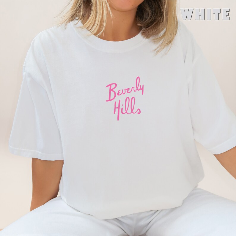 May include: White t-shirt with a pink "Beverly Hills" graphic.