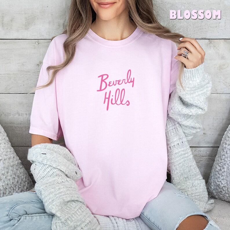 May include: A pink t-shirt with the text "Beverly Hills" in pink script.
