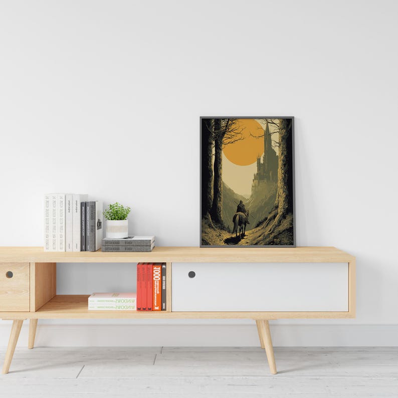 Puede incluir: Impresi&oacute;n art&iacute;stica enmarcada que representa a un jinete a caballo viajando por un bosque hacia un castillo. La obra de arte presenta un gran sol naranja y una paleta de colores apagados de marrones, verdes y amarillos. La impresi&oacute;n se muestra en una pared blanca.