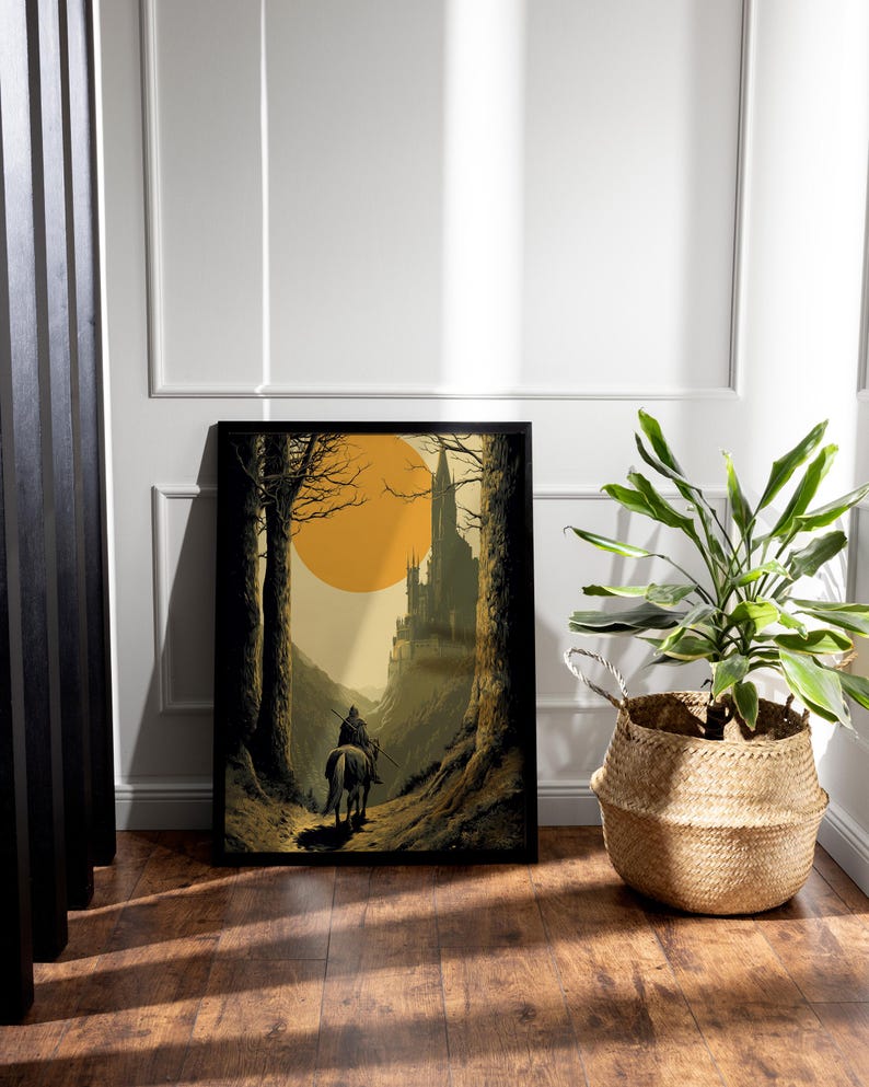 Puede incluir: Impresi&oacute;n art&iacute;stica enmarcada que representa una escena medieval. Una figura a caballo cabalga hacia un castillo, enmarcada por &aacute;rboles y un gran sol amarillo. La obra de arte est&aacute; en un marco negro y se apoya en una pared blanca. Una planta en maceta en una cesta de mimbre est&aacute; cerca.