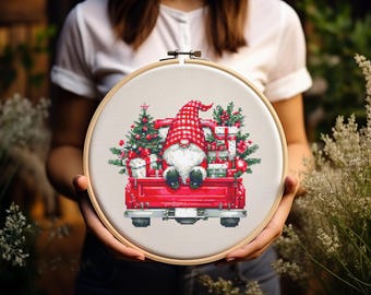Könnte beinhalten: Ein roter Lastwagen mit einem Weihnachtsbaum und Geschenken im Laderaum. Ein Zwerg sitzt im Laderaum des Lastwagens und trägt einen roten Hut. Der Lastwagen steht auf einem weißen Hintergrund.