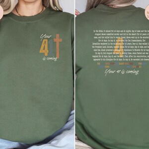 May include: Green sweatshirt with a vintage-style graphic of the number 41 and a cross. The text "Your 41 is coming" is printed below the graphic. The back of the sweatshirt features a text passage about the number 40 in the Bible.