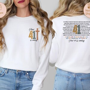 May include: White sweatshirt with a graphic design featuring the number 41 with a cross and the text "Your 41 is coming". The back of the sweatshirt has a longer text about the number 41.