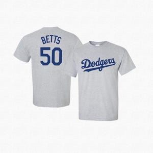 May include: A gray t-shirt with the text "Dodgers" in blue on the front and the text "BETTS 50" in blue on the back.