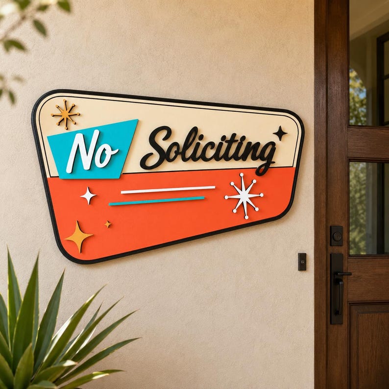 May include: A trapezoidal wall sign with a black border, featuring a cream top section and an orange bottom section. The text "No Soliciting" is written in black and white script. It includes turquoise, orange, and white starburst accents.