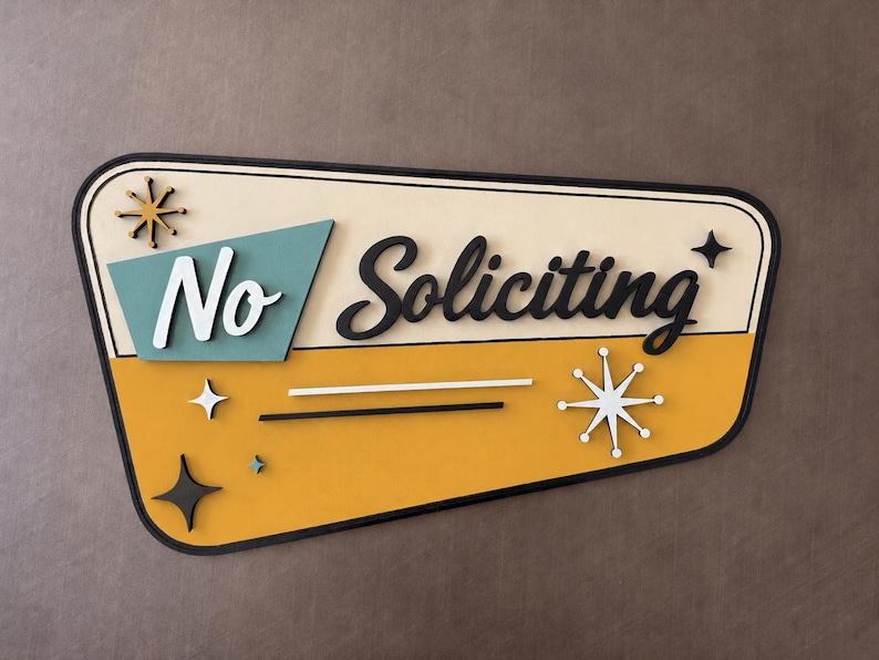 May include: A trapezoidal wall sign with a cream and mustard yellow background featuring the text No Soliciting in black and white script. The sign includes decorative starburst accents in black, white, and teal, all framed by a thick black border.