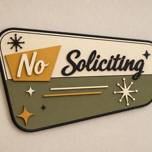 May include: A trapezoidal wall sign with a black border, featuring the text No Soliciting in white and black script. The design includes a mustard yellow accent shape, an olive green background, and decorative starburst icons in black and white.