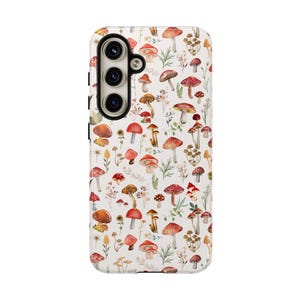 May include: A white phone case with a pattern of red and white mushrooms and green leaves.