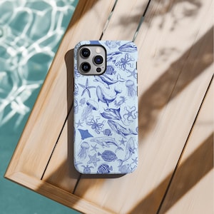 May include: A blue and white phone case with a sea life pattern. The case features a variety of sea creatures, including whales, jellyfish, starfish, and seahorses.