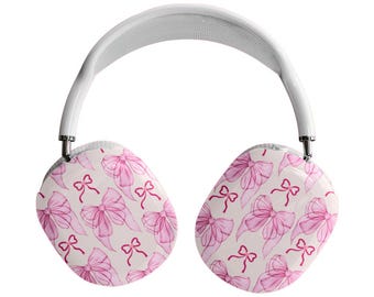 May include: White over-ear headphones with a white headband and earcups. The earcups feature a repeating pattern of pink watercolor bows on a cream background. The headphones have silver metal accents.