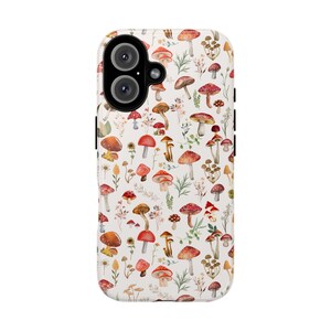 May include: A white phone case with a pattern of red and white mushrooms and green leaves.