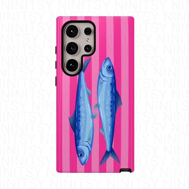 May include: A phone case featuring a vibrant pink and white striped background. Two blue fish are depicted on the case. The phone case has a camera and side buttons.