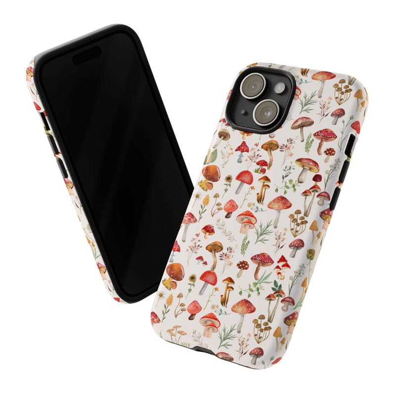 May include: A white phone case with a black border and a pattern of red and brown mushrooms on a white background. The phone case has a cutout for the camera lens.