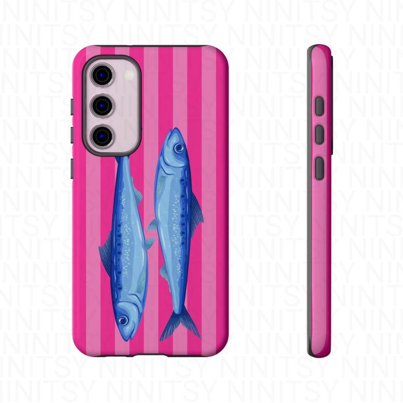 May include: A pink phone case with a vertical striped pattern and two blue fish illustrations. The case has a side view showing the buttons and the camera module.