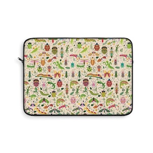 May include: A rectangular laptop sleeve with a black zipper and trim. The sleeve features a repeating pattern of colorful insects, including beetles, butterflies, and dragonflies, on a cream-colored background. Green leaves and floral accents are also included in the design.