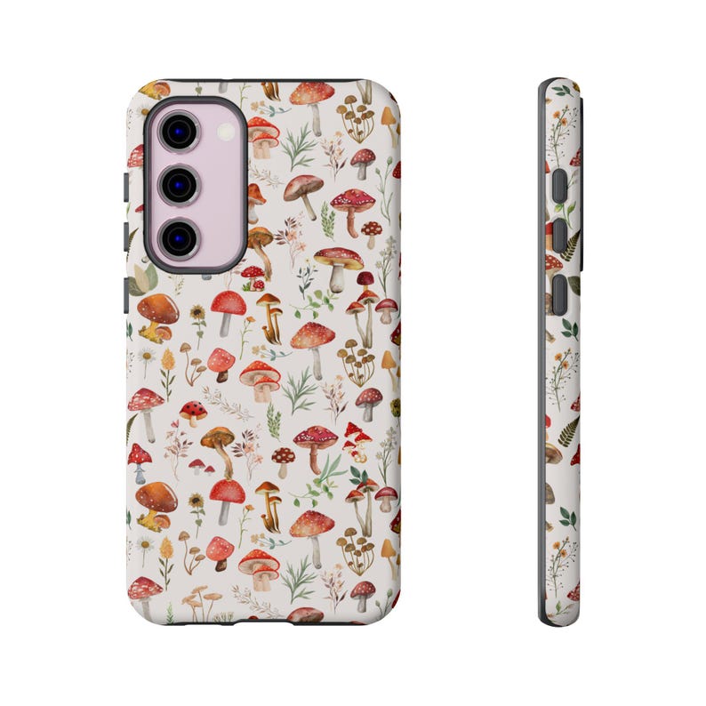 May include: A white phone case with a pattern of red and brown mushrooms on a white background. The case has a cutout for the camera lens.