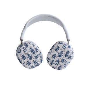 May include: White wireless headphones with a blue and white insect pattern on the earcups.