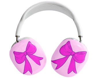 May include: White and silver headphones with pink earcups. Each earcup features a magenta bow design. The headband is white and the earcups are connected by silver metal. The headphones are set against a white background.
