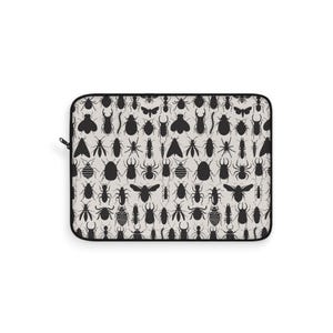 Puede incluir: Una funda rectangular para portátil con un patrón repetido de siluetas de insectos negros sobre un fondo beige claro. Los insectos incluyen varios tipos de escarabajos, arañas y otros insectos. La funda tiene una cremallera y un borde negros.