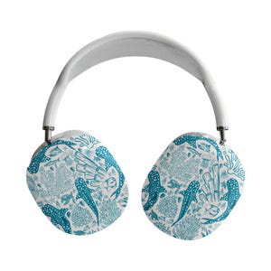 May include: White over-ear headphones with earcups decorated with a teal and white ocean pattern. The design includes illustrations of coral, fish, and manta rays. The headband is white with a mesh top.