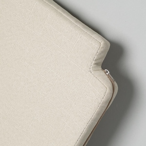 May include: Close-up of a beige fabric headboard with a zipper detail. The headboard has a subtle textured pattern and a clean, modern design.