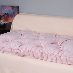 Puede incluir: Un coj&iacute;n de suelo rosa capiton&eacute; con un dise&ntilde;o capiton&eacute; de botones. El coj&iacute;n est&aacute; hecho de una tela suave y mullida y es perfecto para a&ntilde;adir un toque de comodidad y estilo a cualquier habitaci&oacute;n.
