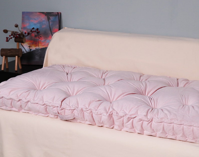 Puede incluir: Un coj&iacute;n de suelo rosa capiton&eacute; con un dise&ntilde;o capiton&eacute; de botones. El coj&iacute;n est&aacute; hecho de una tela suave y mullida y es perfecto para a&ntilde;adir un toque de comodidad y estilo a cualquier habitaci&oacute;n.