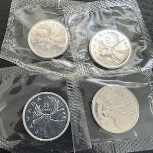 May include: Four Canadian 25-cent coins from 1966, each sealed in a clear plastic pouch. The coins feature a detailed image of a moose and the text "25 Cents" and "Canada".
