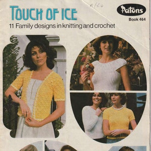 May include: A vintage knitting and crochet pattern book titled "Touch of Ice" with 11 family designs. The cover features photos of people wearing crocheted and knitted garments in various colours, including yellow, white, and pink.