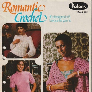 Könnte beinhalten: Ein Vintage-Häkelmusterbuch mit dem Titel "Romantic Crochet" und dem Text "10 designs in 5 favourite yarns". Der Buchumschlag zeigt vier Frauen, die Häkelkleidung in Rosa und Weiß tragen.