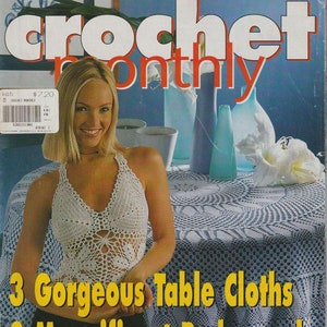 以下が含まれることがあります： クロシェ・マンスリー誌の表紙、268号。白いクロシェの halter top を着た女性と、白いクロシェのテーブルクロスで覆われたテーブルが写っています。表紙のテキストは「3 Gorgeous Table Cloths 2 Magnificent Bedspreads to renew your home deco」です。