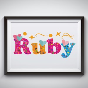 Puede incluir: Una impresión enmarcada con el nombre "Ruby" escrito en letras de colores. Cada letra está llena de pequeños corazones, estrellas y otros elementos decorativos.