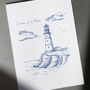 May include: A hand-drawn illustration of a lighthouse on a cliff overlooking the ocean. The sky is blue with white clouds and the text "I wanna go to Maine" is written at the top of the page.