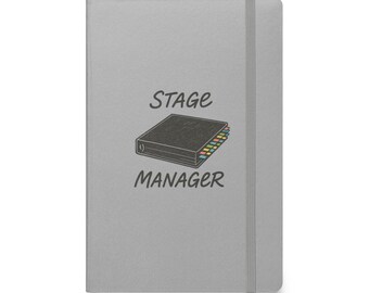 May include: A gray notebook with a black and white illustration of a binder with colorful tabs and the text "STAGE MANAGER".