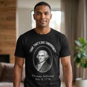 Puede incluir: Camiseta negra con un retrato de Thomas Jefferson en un marco ovalado. El texto sobre el retrato dice "CRAP, THAT'S DUE TOMORROW?!" y debajo, "Thomas Jefferson July 3, 1776."