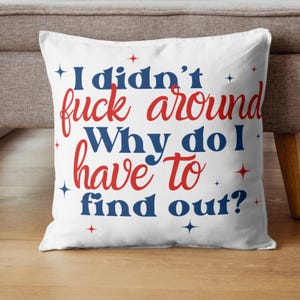 May include: White throw pillow with red and blue text that reads "I didn't fuck around. Why do I have to find out?" with small stars scattered around the text.