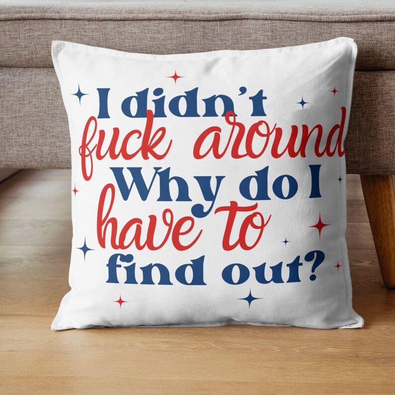 May include: White throw pillow with red and blue text that reads "I didn't fuck around. Why do I have to find out?" with small stars scattered around the text.