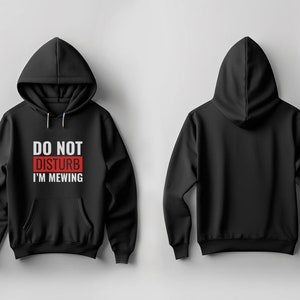 Könnte beinhalten: Schwarzer Hoodie mit einem weißen Aufdruck, der in roten Buchstaben "Do Not Disturb I'm Mewing" lautet.