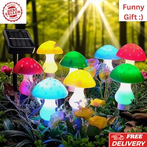 May include: A collection of colorful mushroom-shaped solar garden lights. The lights have red, yellow, green, and blue caps with white stems. The image includes the text "Funny Gift :)" and "Best Seller".
