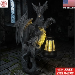 May include: A dark gray dragon statue with a smaller dragon at its feet, holding a black lantern with a warm yellow glow. The statue has large wings and is set against a dark, gothic background. The image includes a "US Seller" graphic.